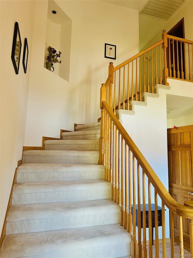 stairway featuring a high ceiling