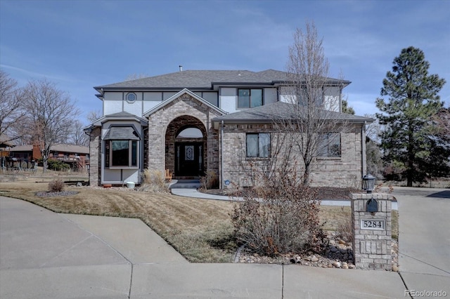 view of front of property with brick siding and roof with shingles