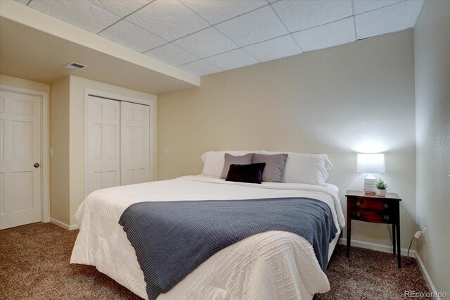 carpeted bedroom featuring a closet and baseboards