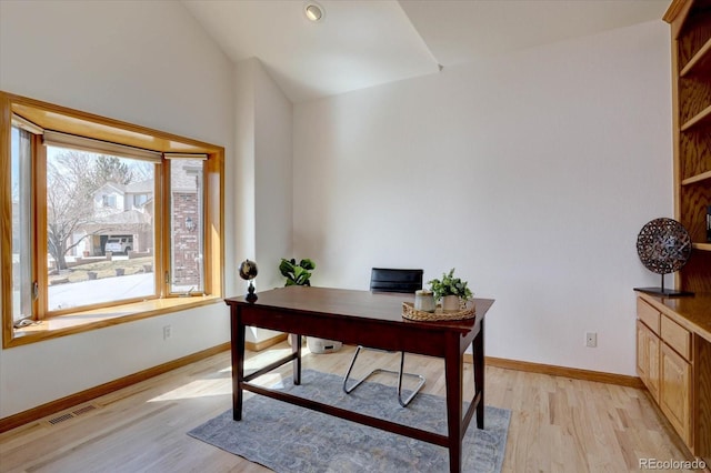 office with light wood-style floors, baseboards, and lofted ceiling