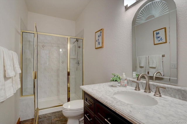 bathroom featuring a stall shower, vanity, and toilet