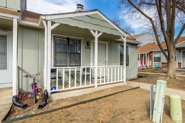 view of exterior entry featuring board and batten siding and covered porch