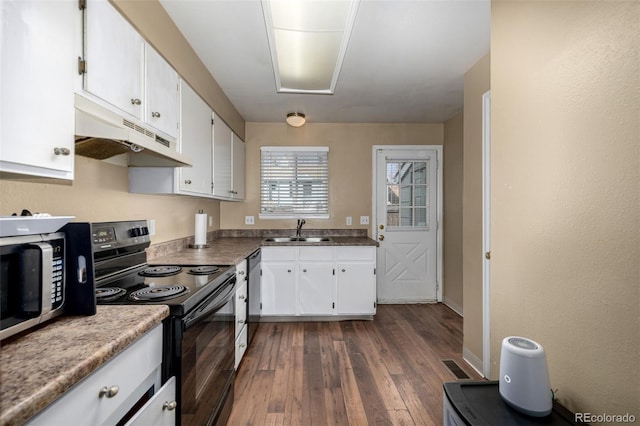 kitchen featuring under cabinet range hood, white cabinetry, appliances with stainless steel finishes, and a sink