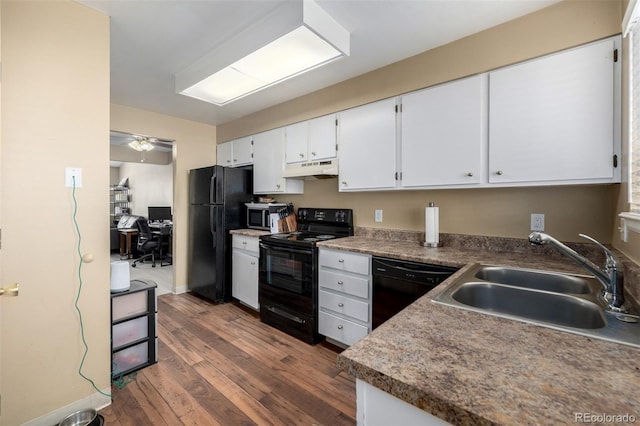 kitchen featuring black appliances, under cabinet range hood, dark wood-style floors, white cabinetry, and a sink