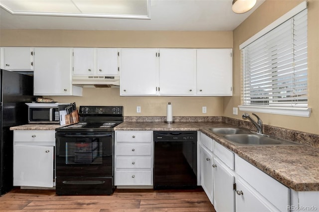 kitchen featuring black appliances, under cabinet range hood, dark wood-style floors, white cabinetry, and a sink