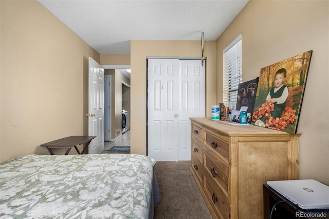 carpeted bedroom featuring a closet, washer / clothes dryer, and a textured ceiling