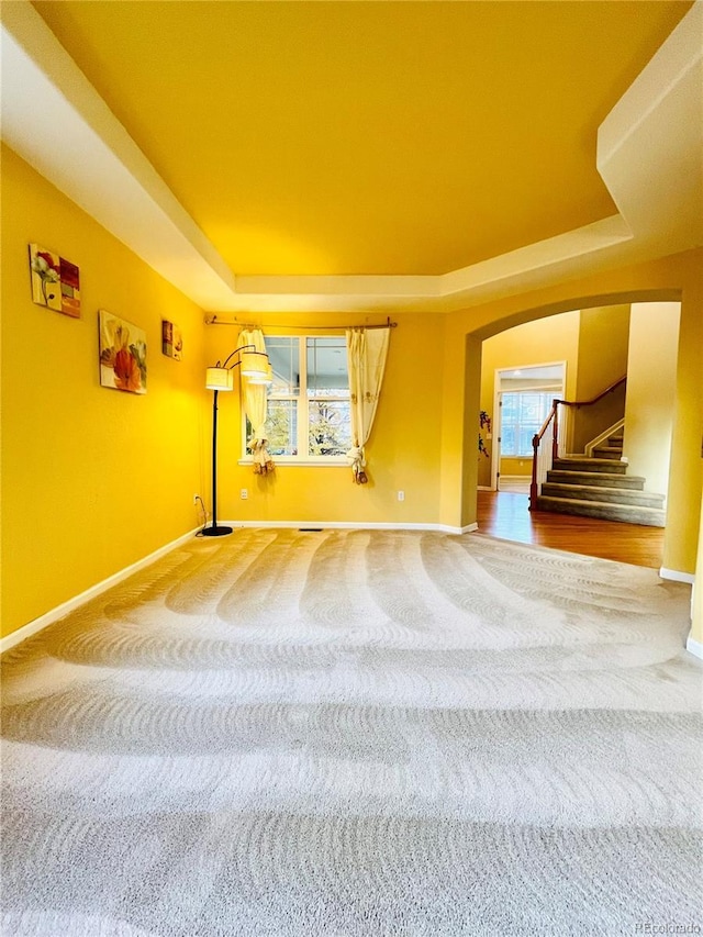 16866 E Peakview Ave, Aurora, CO 80016 - empty room with a tray ceiling, carpet, arched walkways, and stairs