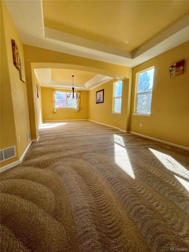16866 E Peakview Ave, Aurora, CO 80016 - unfurnished room featuring a raised ceiling, carpet floors, a chandelier, and arched walkways