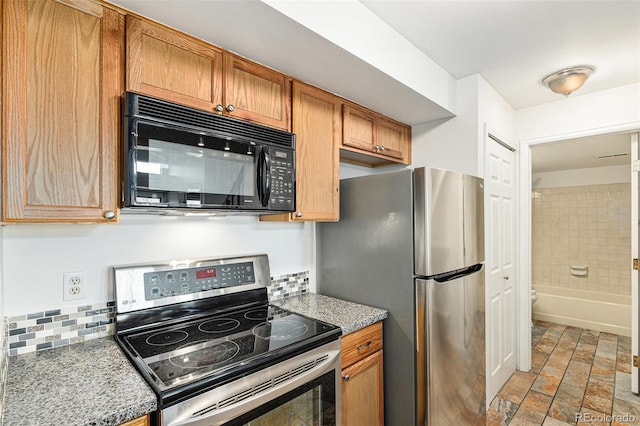 kitchen with appliances with stainless steel finishes, light stone finish floors, decorative backsplash, and brown cabinetry