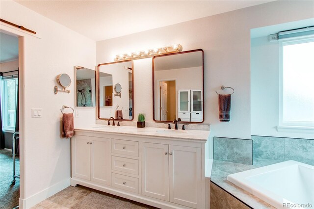 bathroom with plenty of natural light, double vanity, and a bath