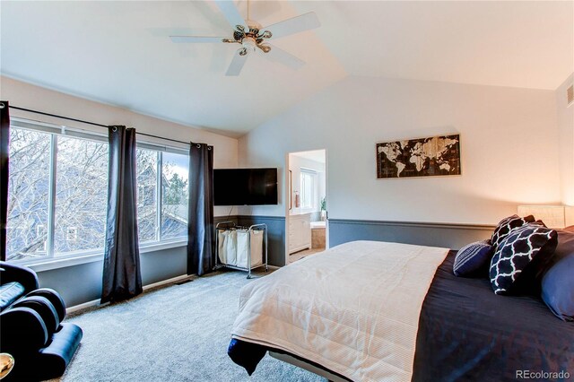 carpeted bedroom featuring vaulted ceiling, baseboards, ensuite bathroom, and ceiling fan