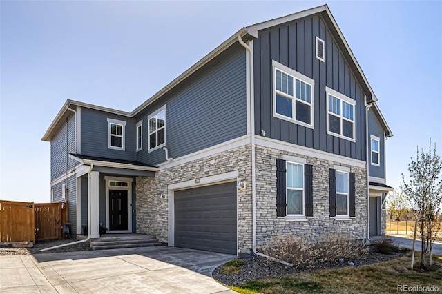 4522 Barrow Ln, Timnath, CO 80547 - view of front facade with board and batten siding, an attached garage, driveway, and stone siding
