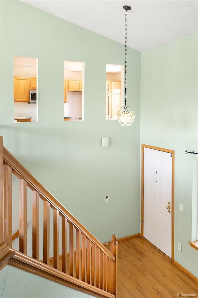 8879 Apache Plume Dr, Parker, CO 80134 - entryway with light wood-type flooring, a chandelier, baseboards, and stairway