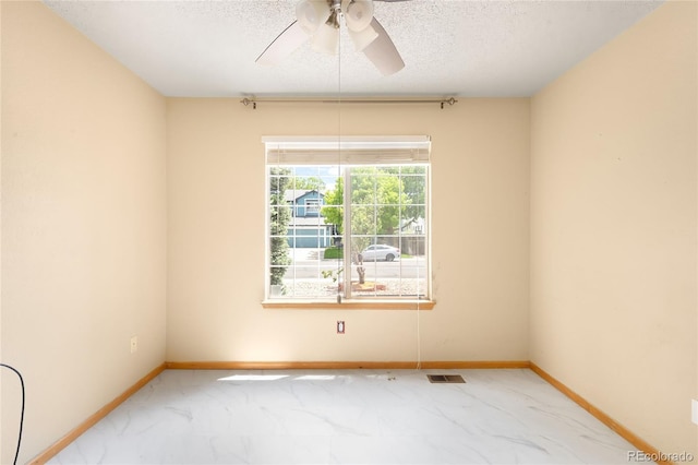 8879 Apache Plume Dr, Parker, CO 80134 - spare room featuring ceiling fan, a textured ceiling, baseboards, and marble look tiles