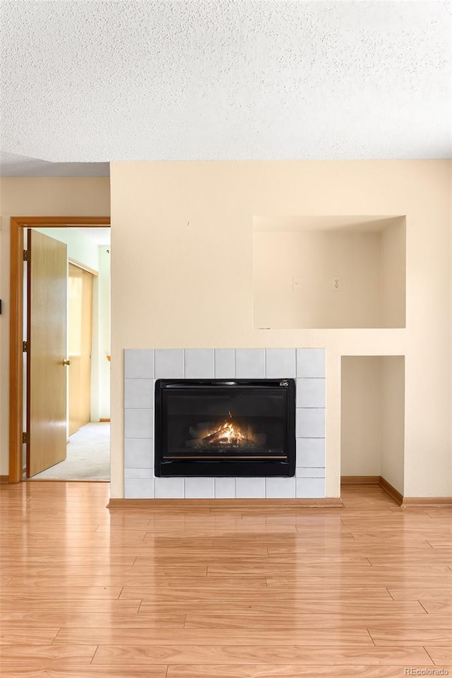 8879 Apache Plume Dr, Parker, CO 80134 - detailed view of a fireplace, wood finished floors, baseboards, and a textured ceiling