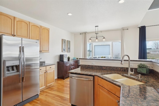 16665 Kenuil St, Brighton, CO 80603 - kitchen featuring stainless steel appliances, a sink, light wood-style floors, recessed lighting, and decorative light fixtures