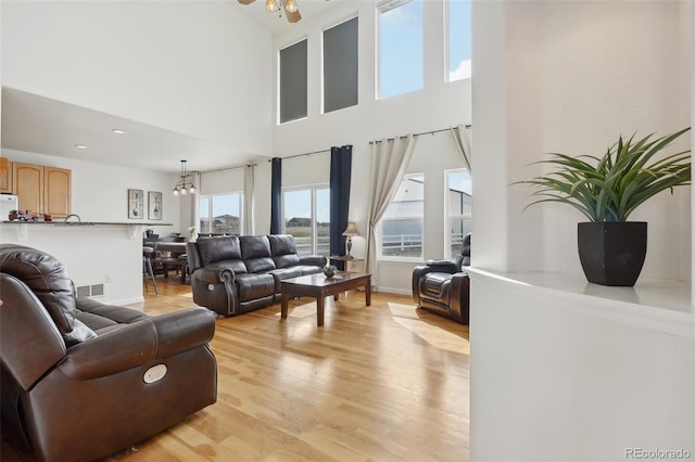 16665 Kenuil St, Brighton, CO 80603 - living room featuring light wood-style floors, a high ceiling, and ceiling fan