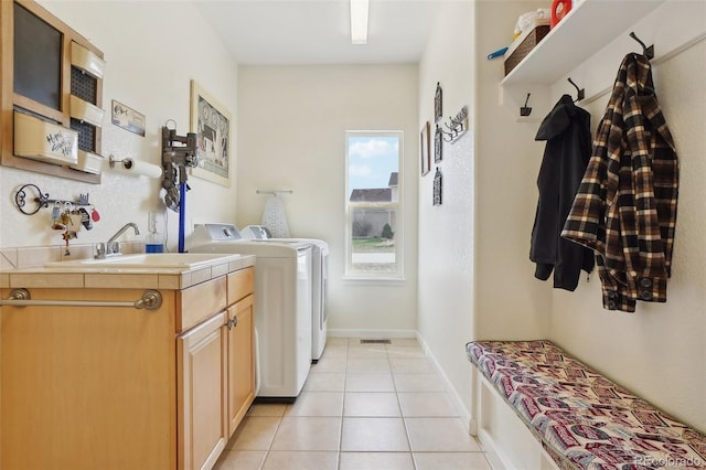 16665 Kenuil St, Brighton, CO 80603 - laundry area featuring washing machine and dryer, light tile patterned floors, and cabinet space