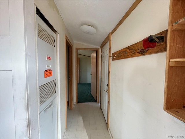 hall featuring light tile patterned floors and crown molding