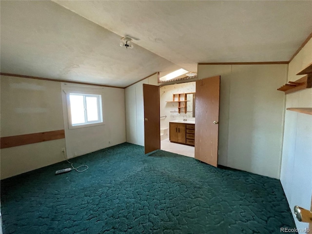 interior space with carpet, a textured ceiling, vaulted ceiling, and sink