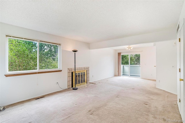 72 S Nome St, Aurora, CO 80012 - unfurnished living room with carpet flooring, a textured ceiling, and a tile fireplace