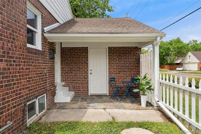 1691 Roslyn St, Denver, CO 80220 - view of exterior entry featuring brick siding and a shingled roof