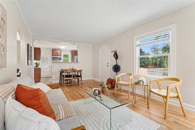 1691 Roslyn St, Denver, CO 80220 - living room featuring arched walkways, healthy amount of natural light, light wood-type flooring, crown molding, and baseboards
