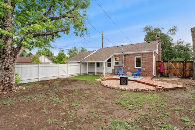1691 Roslyn St, Denver, CO 80220 - back of property with a fenced backyard, a deck, a chimney, and central AC