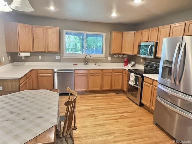 13313 Elizabeth St, Thornton, CO 80241 - kitchen featuring stainless steel appliances, light wood-style flooring, light countertops, light brown cabinetry, and recessed lighting