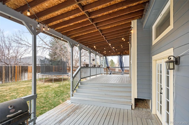 13313 Elizabeth St, Thornton, CO 80241 - wooden terrace featuring a trampoline, a fenced backyard, and french doors