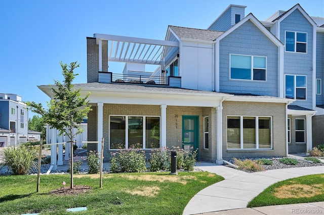 888 S Valentia St Unit 20-101, Denver, CO 80247 - view of front facade with a balcony, a porch, brick siding, and a front yard