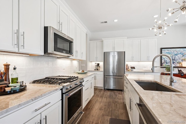 888 S Valentia St Unit 20-101, Denver, CO 80247 - kitchen featuring high end appliances, white cabinets, tasteful backsplash, light stone countertops, and recessed lighting