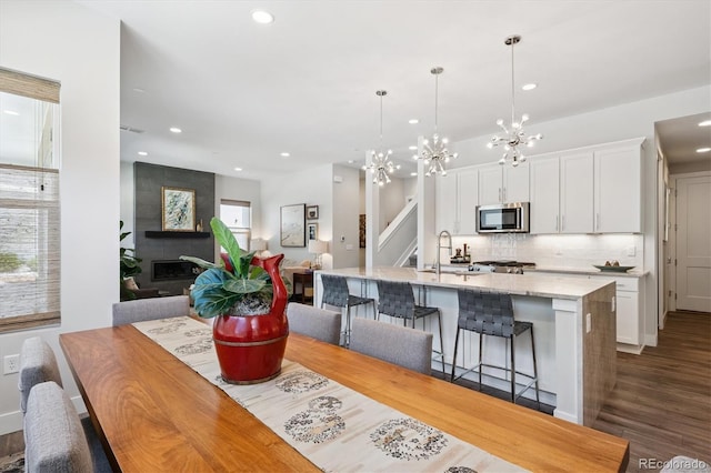 888 S Valentia St Unit 20-101, Denver, CO 80247 - dining room featuring recessed lighting, dark wood-style floors, a chandelier, and a fireplace
