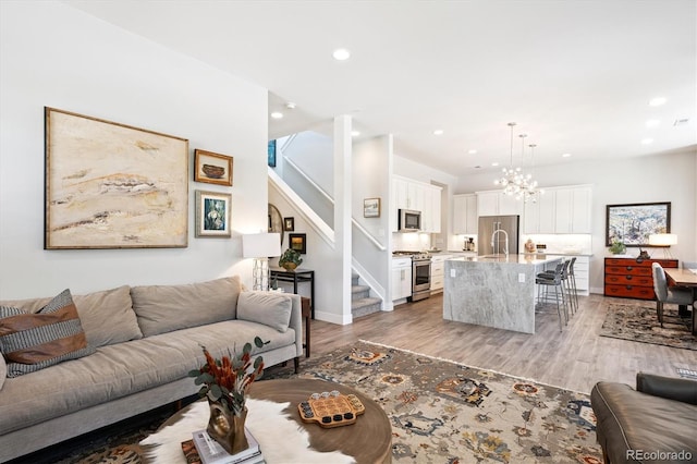 888 S Valentia St Unit 20-101, Denver, CO 80247 - living room featuring recessed lighting, stairway, light wood-style floors, and a chandelier
