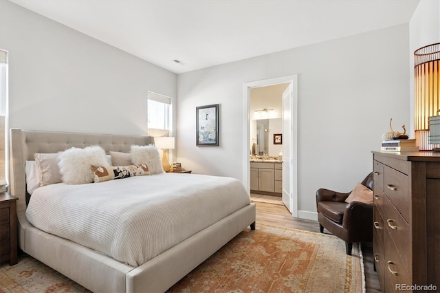 888 S Valentia St Unit 20-101, Denver, CO 80247 - bedroom featuring light wood-style flooring and ensuite bath