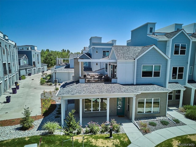 888 S Valentia St Unit 20-101, Denver, CO 80247 - back of property with roof with shingles, a patio area, and a residential view