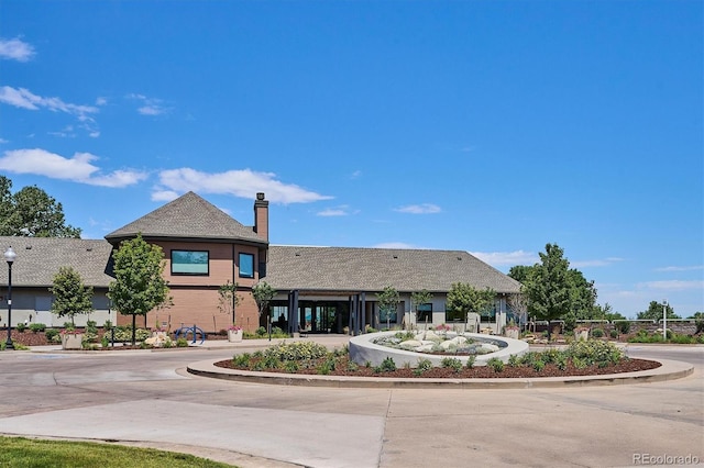 888 S Valentia St Unit 20-101, Denver, CO 80247 - view of front facade with a chimney and curved driveway