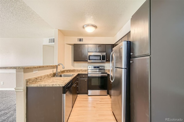 kitchen with light wood-type flooring, visible vents, appliances with stainless steel finishes, and a sink