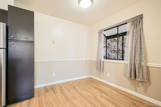 unfurnished room featuring baseboards and wood finished floors