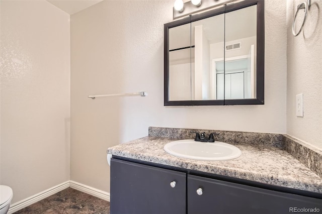 bathroom featuring vanity, toilet, baseboards, and visible vents