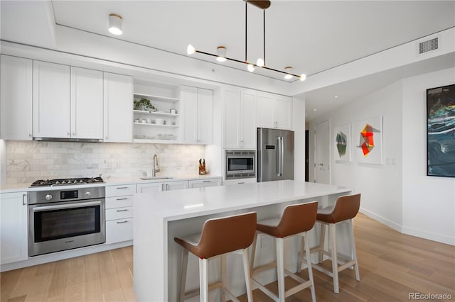 1750 Wewatta St Unit 1720, Denver, CO 80202 - kitchen with appliances with stainless steel finishes, decorative backsplash, a sink, a kitchen breakfast bar, and light countertops
