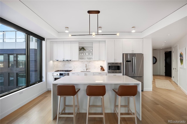 1750 Wewatta St Unit 1720, Denver, CO 80202 - kitchen with stainless steel appliances, a sink, a kitchen island, a breakfast bar, and white cabinets
