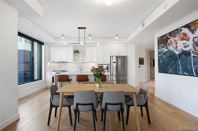 1750 Wewatta St Unit 1720, Denver, CO 80202 - dining area featuring baseboards and light wood-type flooring