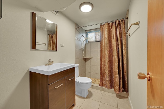 bathroom with toilet, a tile shower, tile patterned floors, and vanity