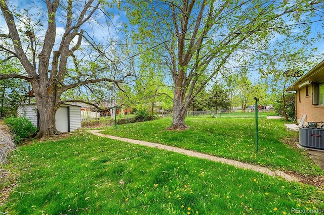 view of yard with an outdoor structure, central AC, and a shed