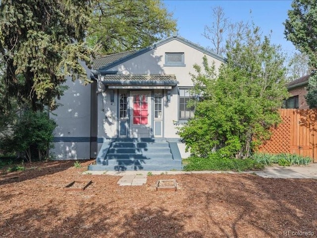 view of front of home featuring fence and stucco siding