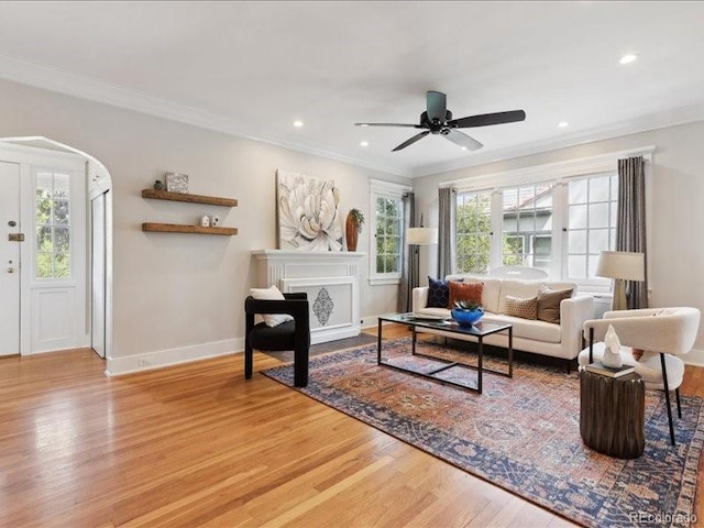 living area with wood finished floors, ornamental molding, baseboards, a ceiling fan, and recessed lighting