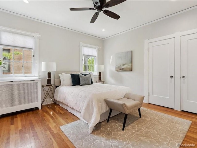 bedroom featuring radiator, crown molding, wood finished floors, a ceiling fan, and recessed lighting