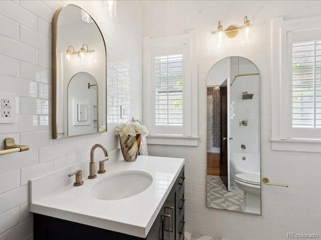 full bath with tile walls, vanity, a shower, tile patterned floors, and a bathtub
