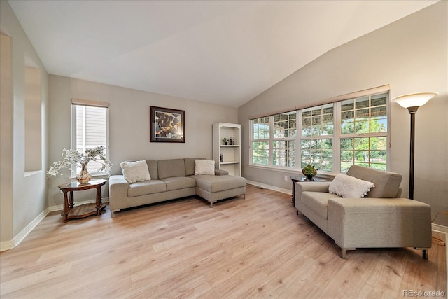 living area with light wood finished floors, lofted ceiling, and baseboards